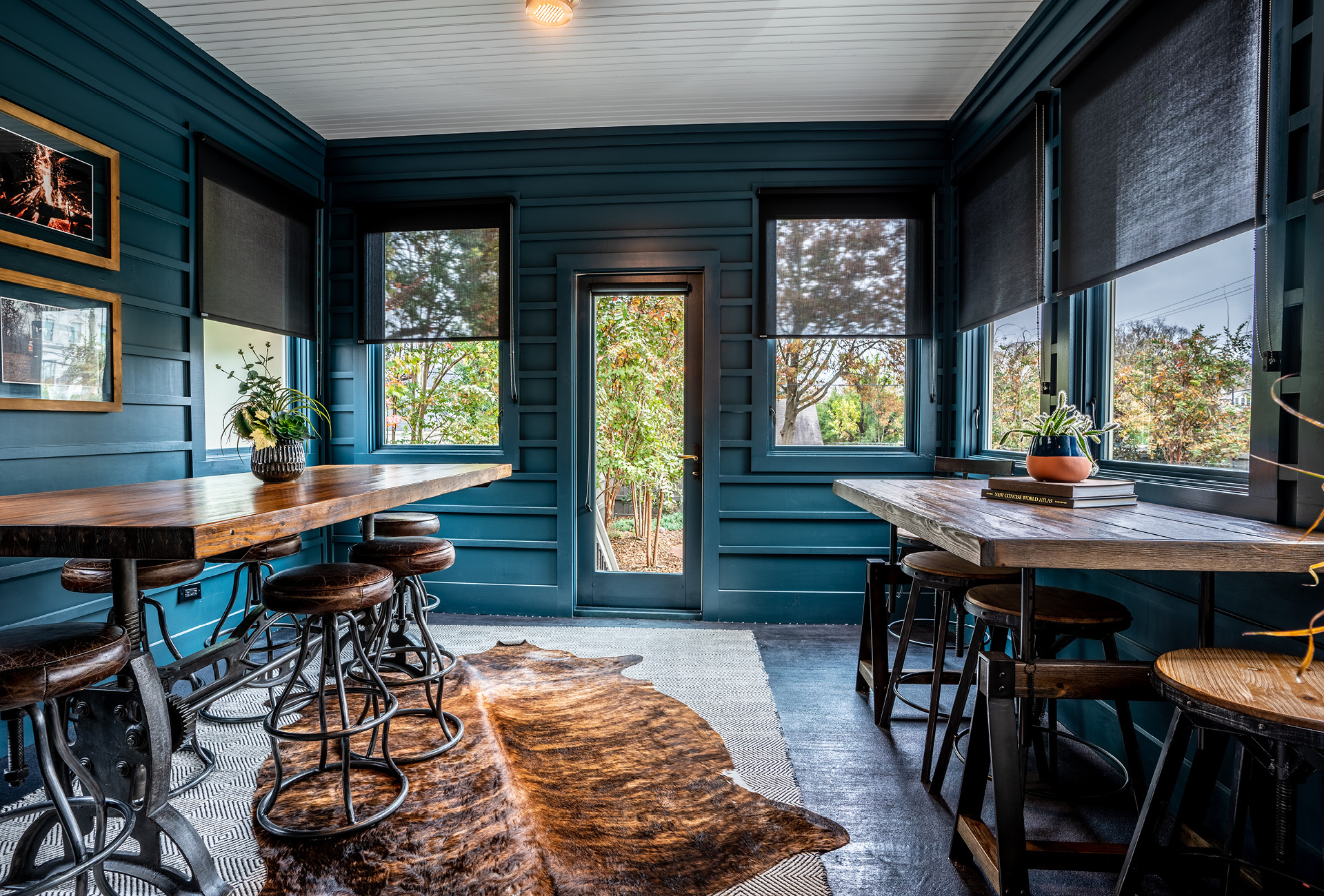 Two large tables in a gorgeous sunroom that leads out to the backyard