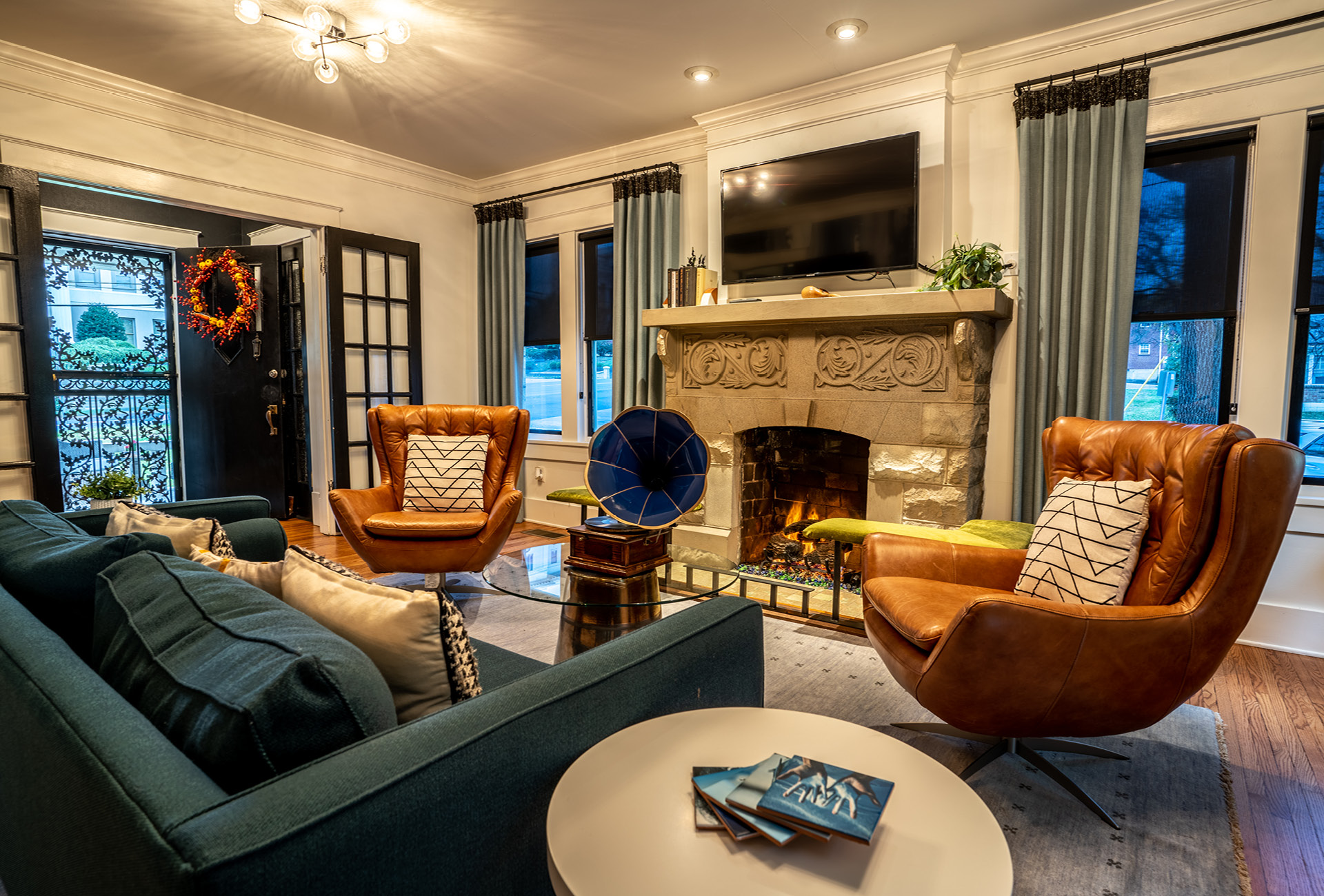 A couch, fireplace, and leather chairs in The NashVilla main room