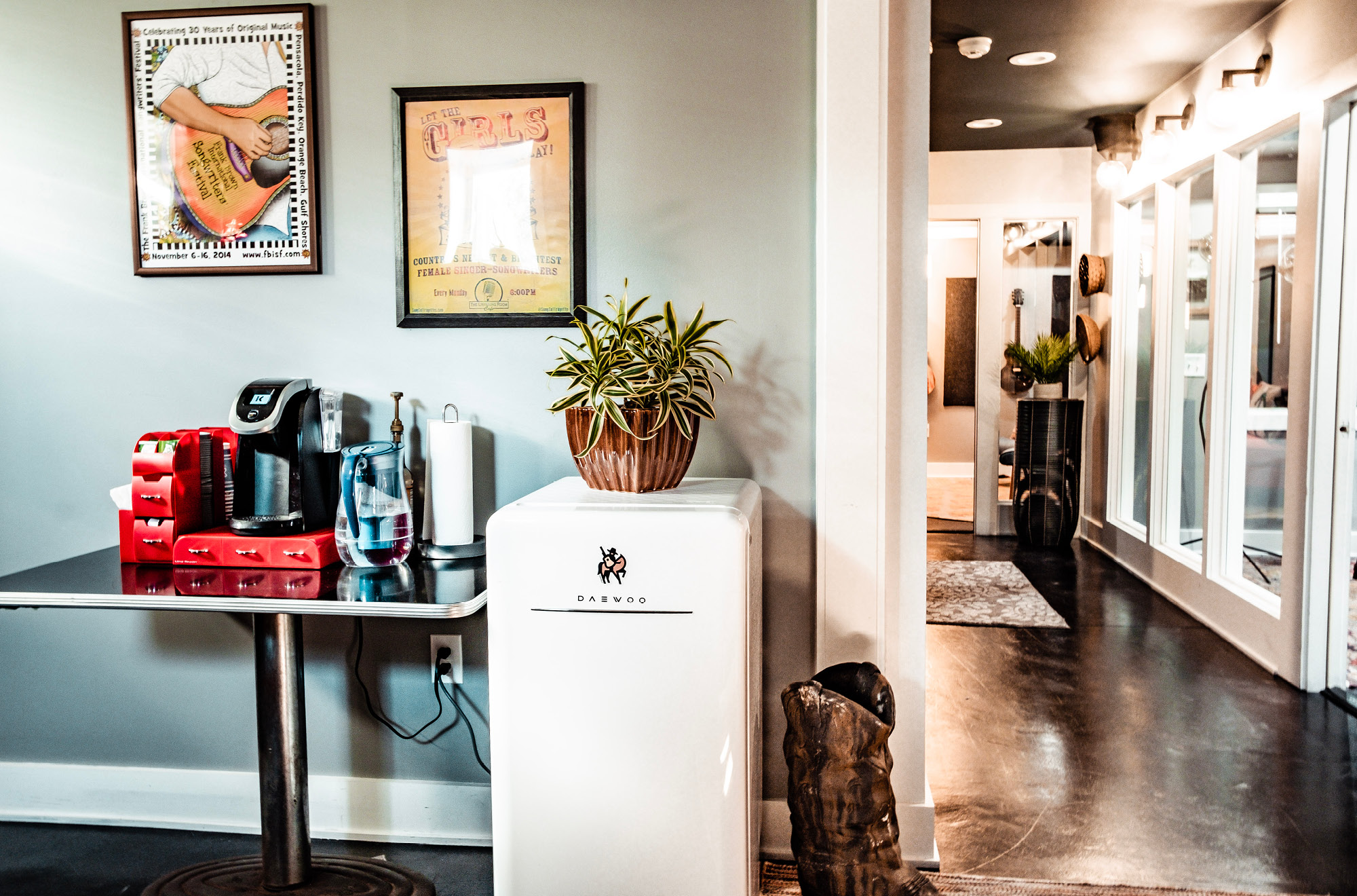 a bright, cozy basement with a coffee machine and a mini-fridge