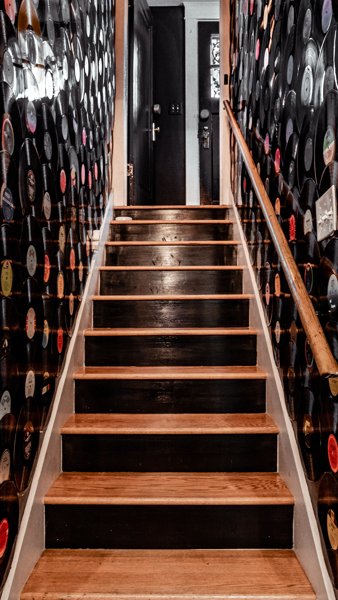 A stairwell lined floor-to-ceiling with vinyl records