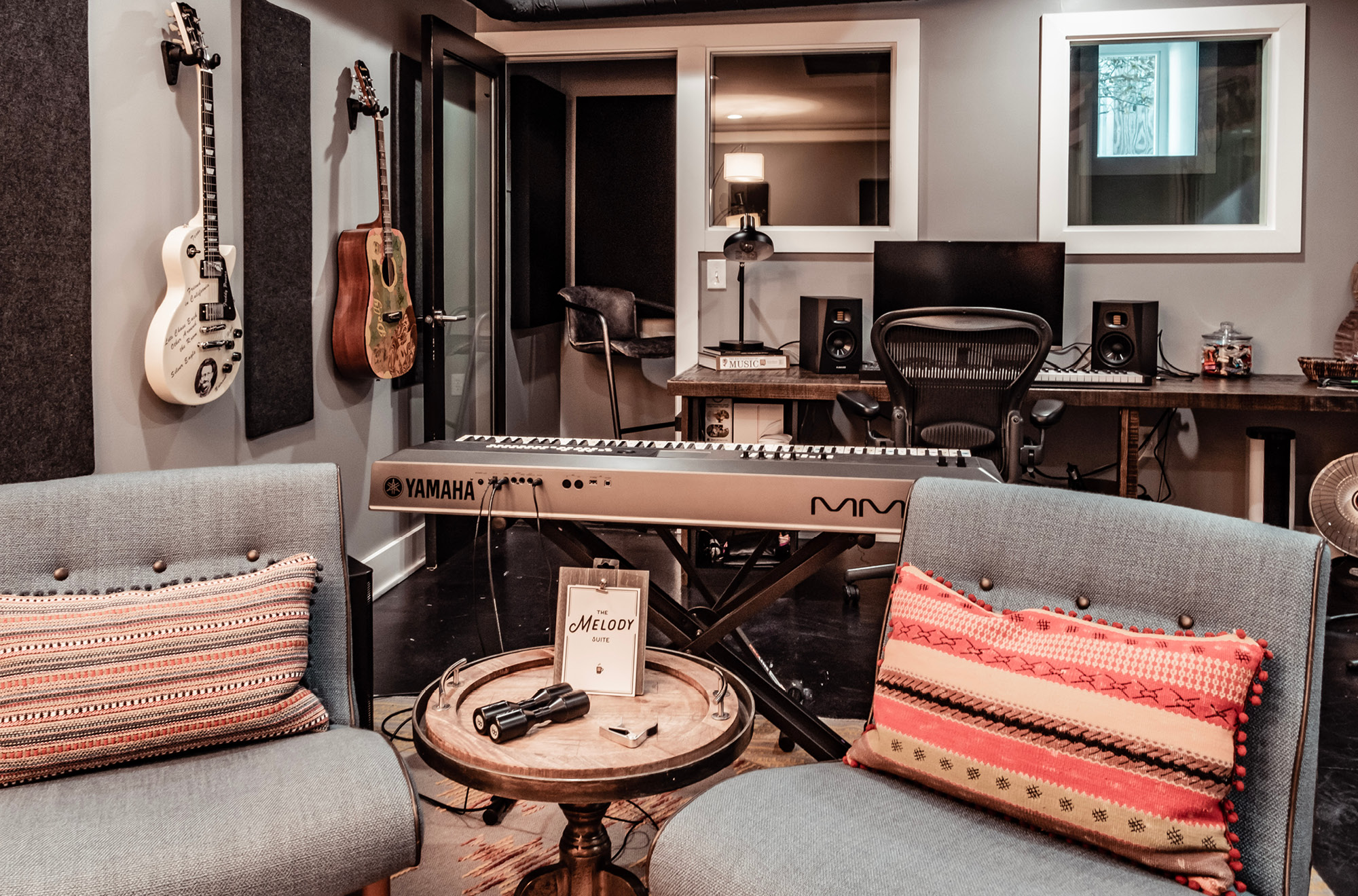 One of our writers rooms, equipped with a keyboard, guitars, and comfortable seating